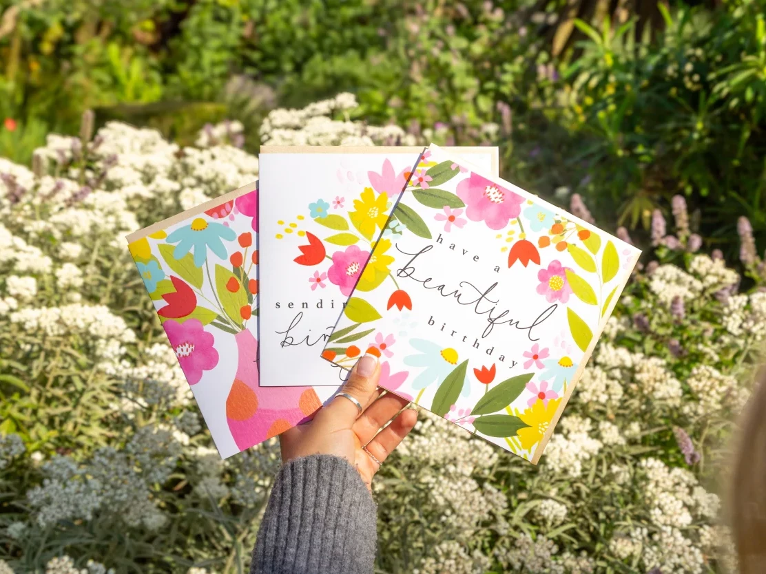 Whistlefish Shopify Bespoke Store Design image of a someone holding some cards outside