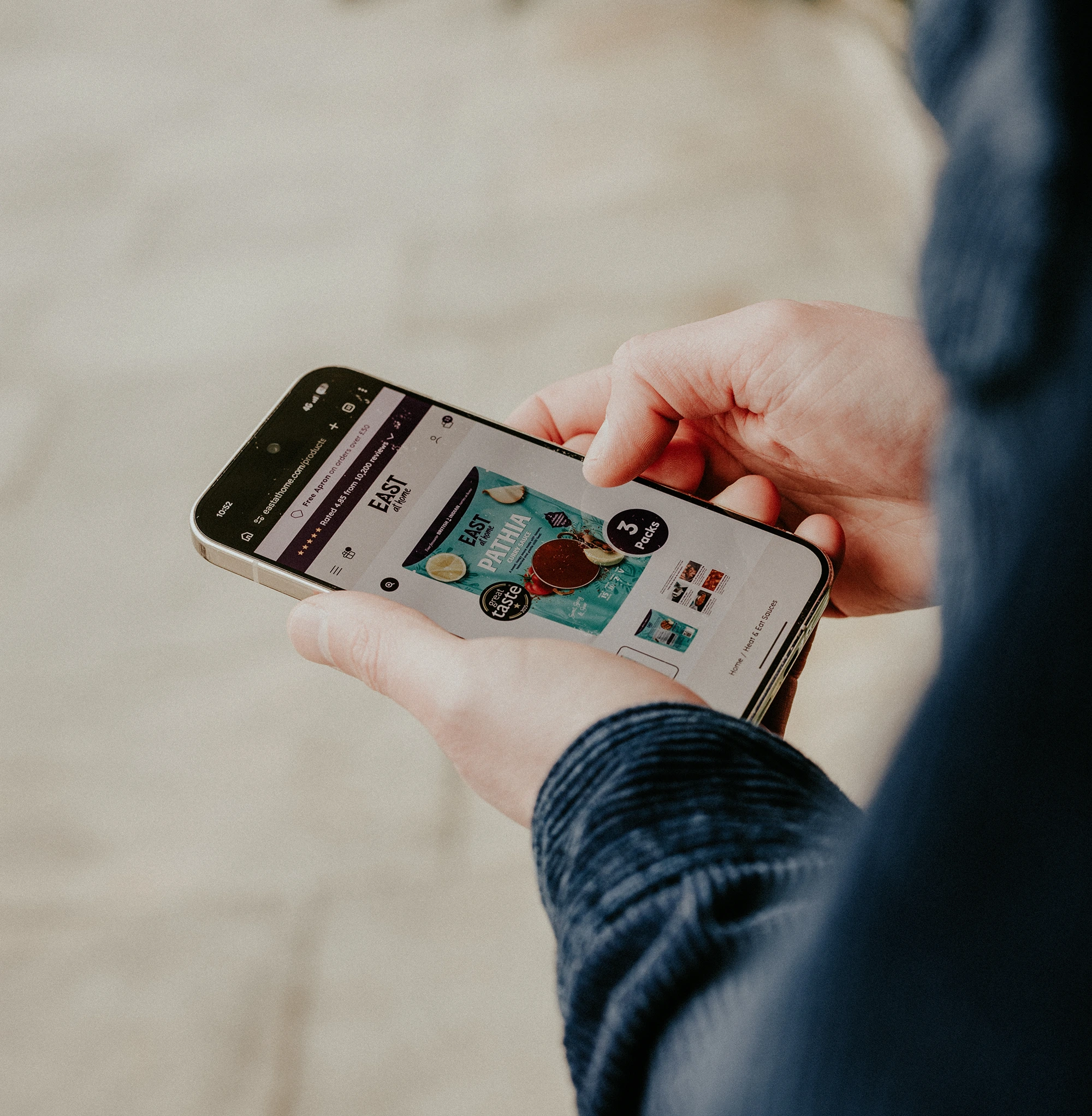 Photo of me holding a mobile device which has the East at Home Shopify Website Design by Anthony is Freelance