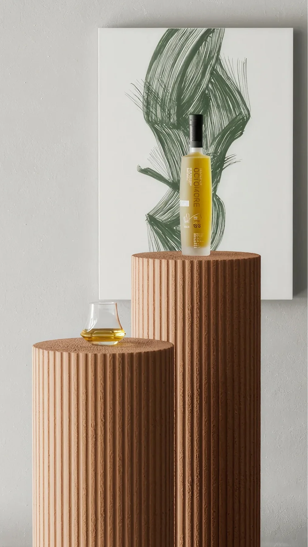 Yellow bottle centered on a tall ribbed brown pedestal, with a small glass of amber liquid on a shorter pedestal, and abstract green art in the background.